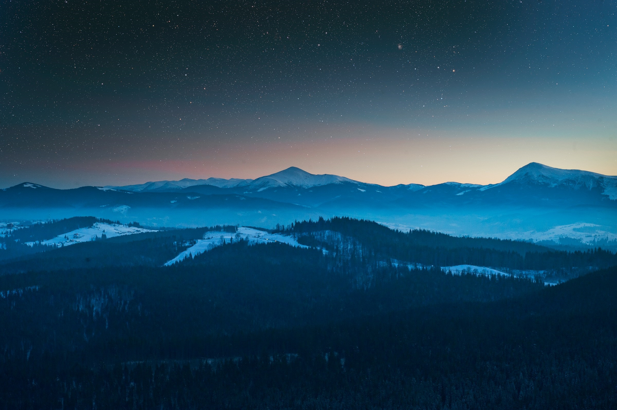 A picture of a sunset with the stars and mountains visible, as well as a shooting star across the center.